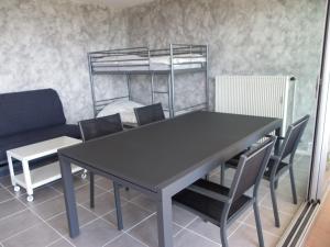 - une table à manger avec des chaises et des lits superposés dans l'établissement Studio avec splendide vue sur mer, au Lavandou 3 autres photos