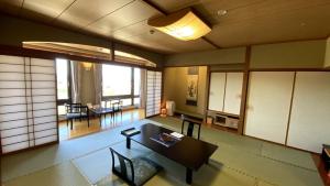 a living room with a table and a dining room at Hotel Morinokaze Oshuku in Shizukuishi