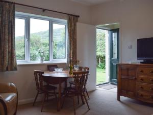 a dining room with a table and chairs and a window at Cobbs Cottage in Grosmont