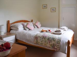 a bedroom with a bed with a tray of food on it at Cobbs Cottage in Grosmont