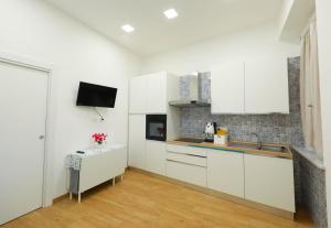 a kitchen with white cabinets and a sink at Vient' e mar suite in Castellammare di Stabia