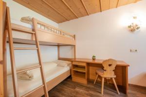 a bedroom with bunk beds and a desk and a ladder at Stacklerhof in Neustift im Stubaital