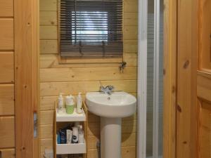 La salle de bains est pourvue d'un lavabo blanc et d'une fenêtre. dans l'établissement Gooseberry Lodge, à Tollard Royal
