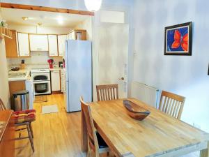 cocina con mesa de madera y nevera en Bay Apartment, en Rothesay