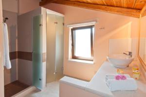 a bathroom with a white sink and a window at Kymaros Villas in Keri +39 photos