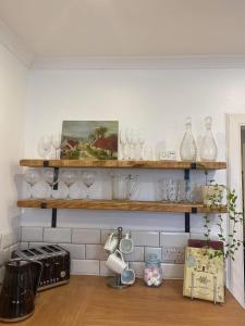 a kitchen with wooden shelves filled with wine glasses at NewburghAprtment Scotland sleeps 4 FirePit Garden in Cupar