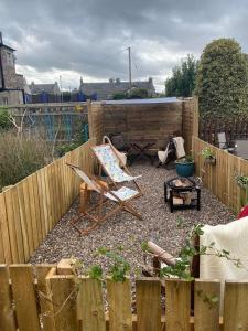 a garden with a wooden fence and a chair at Stunning Apartment in Newburgh Scotland sleeps 4 in Cupar