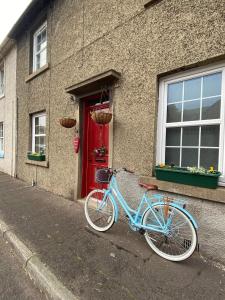 una bicicletta blu parcheggiata fuori da un edificio con una porta rossa di Stunning Apartment in Newburgh Scotland sleeps 4 a Cupar