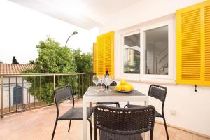 un patio con tavolo e sedie sul balcone. di Apt RIERES a Port de Pollença
