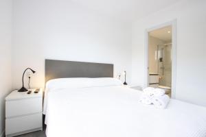 a bedroom with a white bed and a mirror at Apt RIERES in Port de Pollensa