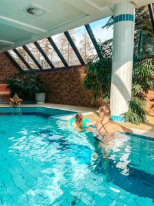 Deux enfants jouent dans une piscine. dans l'établissement Rodinný Hotel Hubert High Tatras, à Vysoké Tatry