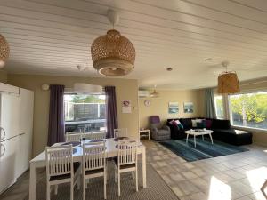 a kitchen and living room with a table and chairs at Villa Arktika porealtaallinen mökki Nuorgamissa Tenojoen ja tunturien vieressä in Nuorgam