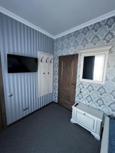 a room with a tv and a door and a window at Zolotoy Fazan in Mykolaiv