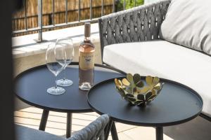 uma garrafa de vinho e duas mesas com copos de vinho em Modern and Vibrant 2BR apartment with Private Balcony by Sea N' Rent em Tel Aviv