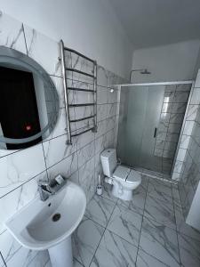 a white bathroom with a sink and a toilet at Zolotoy Fazan in Mykolaiv +20 photos