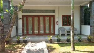 a house with a red door and a chair in a yard at The Gecho Inn Country in Jepara