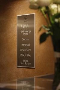 a sign that is on a wall with a plant at Palmon Bay Hotel & Spa in Herceg-Novi
