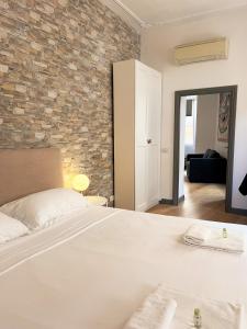 a bedroom with a white bed and a brick wall at Pantheon Rome Relais in Rome