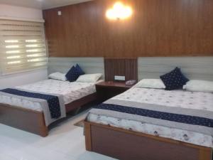 a bedroom with two beds and a nightstand and sidx sidx sidx sidx at Hotel SU kataragama in Kataragama