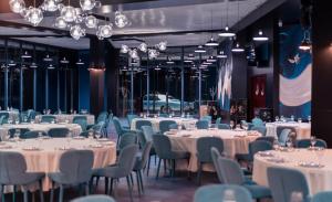 Litz Resort في كفارياتي: قاعة حفلات بها طاولات وكراسي وثريات بيضاء