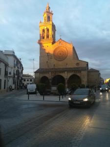 een gebouw met een klokkentoren met een auto ervoor bij CASA ALFONSO in Córdoba