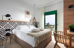 Un dormitorio con una cama y una mesa con toallas. en Beachfront Villa on Crete - Kirvas, member of Pelagaios Villas, en Koutsounari