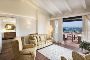 a living room with a couch and chairs and a balcony at Hotel Abi d'Oru in Porto Rotondo