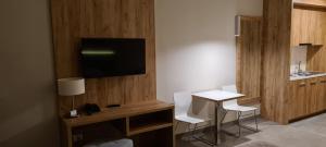 Habitación con mesa, 2 sillas y TV. en Aparthotel Czarna Gora 213, en Sienna