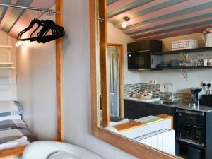 um quarto com um espelho e uma cozinha com um balcão em The Rocking Lodge em Threlkeld