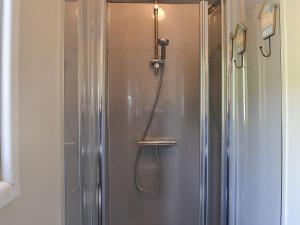 um chuveiro na casa de banho com um frigorífico de metal em The Rocking Lodge em Threlkeld