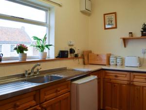 uma cozinha com um lavatório e uma janela em Crail House em Crail