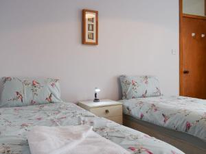 um quarto com duas camas e uma foto na parede em Crail House em Crail