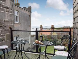 a balcony with two tables and chairs with a view at Crail House in Crail