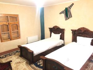 Habitación con 2 camas y ventana en Ali Nur en Bukhara