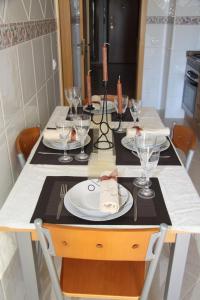 una mesa de comedor con platos y vasos. en Apartamento Arade Portimao, en Portimão