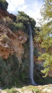 una cascada a un lado de una montaña rocosa en Casa El Olmo de Navajas en Navajas