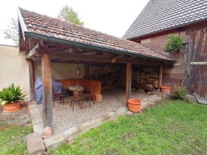 un pabellón de madera con una mesa y sillas en un patio en Os-Auszeit, en Oberschwarzach