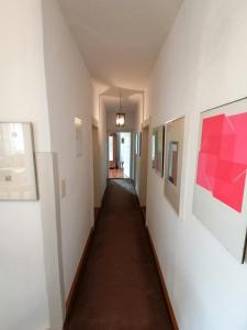 a long hallway with paintings on the walls at Os-Auszeit in Oberschwarzach