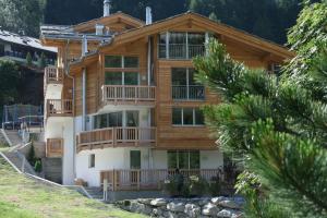 ein großes Holzhaus mit Balkon auf einem Hügel in der Unterkunft Chalet Lea in Zermatt