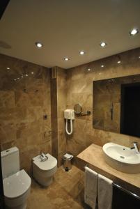 un baño con inodoro y lavabo en Hotel Hyltor, en Archena