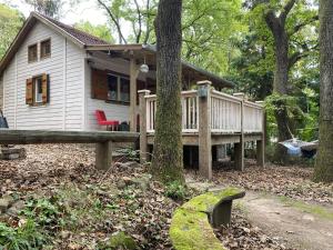 ein kleines Haus mit einer Terrasse im Wald in der Unterkunft Mesebeli Vendégház in Kismaros