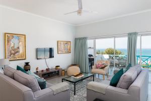 una sala de estar con 2 sofás y vistas al océano. en Aruba 16, en Ballito