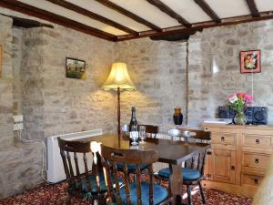 uma sala de jantar com mesa e cadeiras em Buzzard Cottage em Devynock