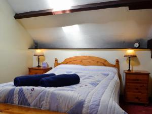 uma cama com duas almofadas azuis num quarto em Buzzard Cottage em Devynock