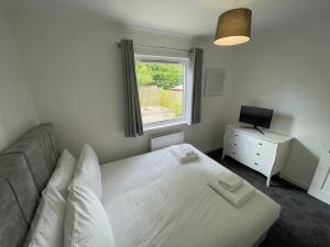 a bedroom with a bed and a desk and a window at Casa Fresa - Kintail House in Broughty Ferry