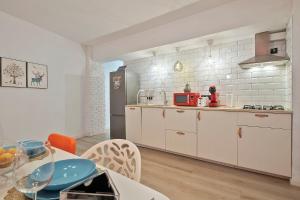 una cocina con armarios blancos y una mesa en una habitación en Apartament Mercado Central, en Alicante