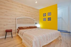 1 dormitorio con cama y pared amarilla en Apartament Mercado Central, en Alicante