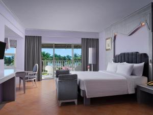 um quarto com uma grande cama branca e uma secretária em Aonang Villa Resort I Beach Front em Praia de Aonang
