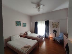 um quarto com 2 camas e uma janela em Apartment 110 sqm free parking em Patra