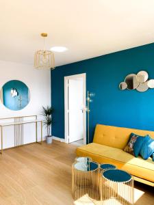 Vue panoramique sur Paris : Sublime appartement au centre de Courbevoie في كوربفوا: غرفة معيشة مع أريكة صفراء وجدار أزرق